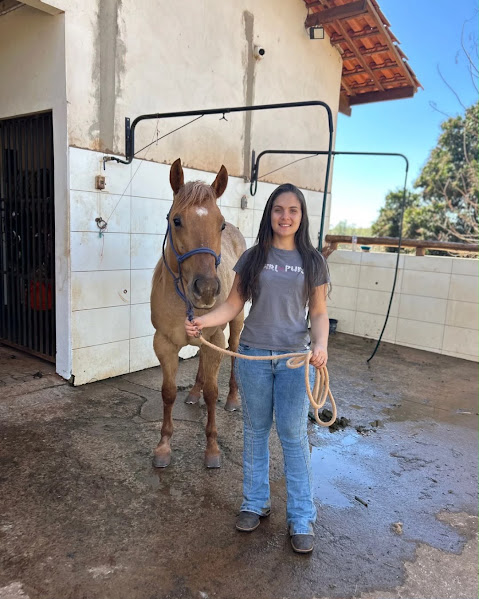 Stephani Nardoni, médica-veterinária equina, ao lado de um cavalo