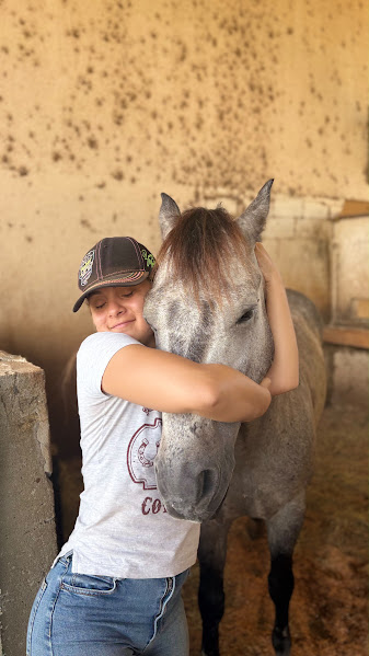 Stephani Nardoni em contato próximo com um cavalo na baia